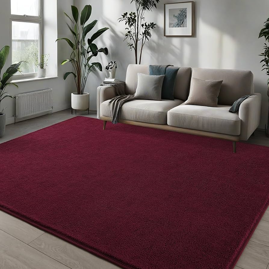 Living room with a red rug, beige sofa, and plants