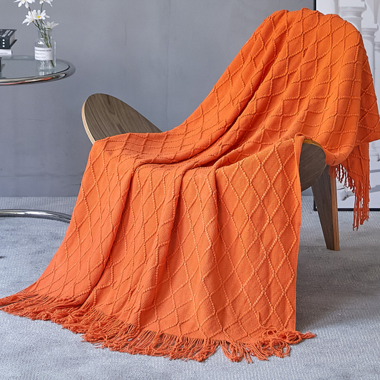 Orange textured blanket draped over a chair with a neutral background
